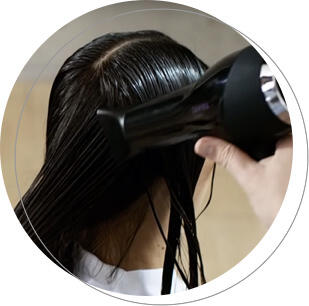 Esta imagem contém um cabeleireiro que trata o cabelo de um cliente no salão.